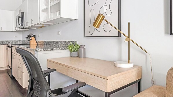 A modern kitchen with white cabinets, a granite countertop, and a built-in oven.