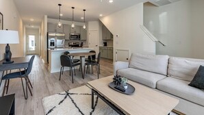 A modern apartment with a dining area, kitchen, and living room.