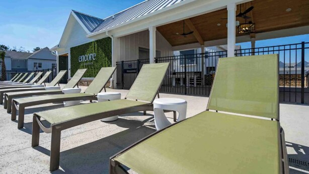 A row of sun loungers under a covered area with a sign reading "Encore".