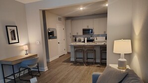 Un apartamento moderno con kitchenette, comedor y sala de estar.