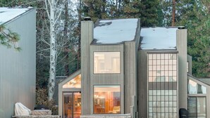 A modern wooden cabin with large windows and a covered outdoor seating area. - Black Butte Ranch Country House 065 (Black Butte Ranch)