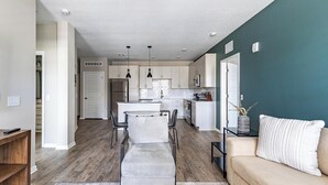 A modern kitchen with white cabinets, a central island, and pendant lighting.
