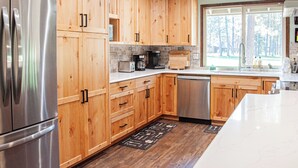 Una cocina moderna con armarios de madera, electrodomésticos de acero inoxidable y un amplio ventanal con vistas al exterior.