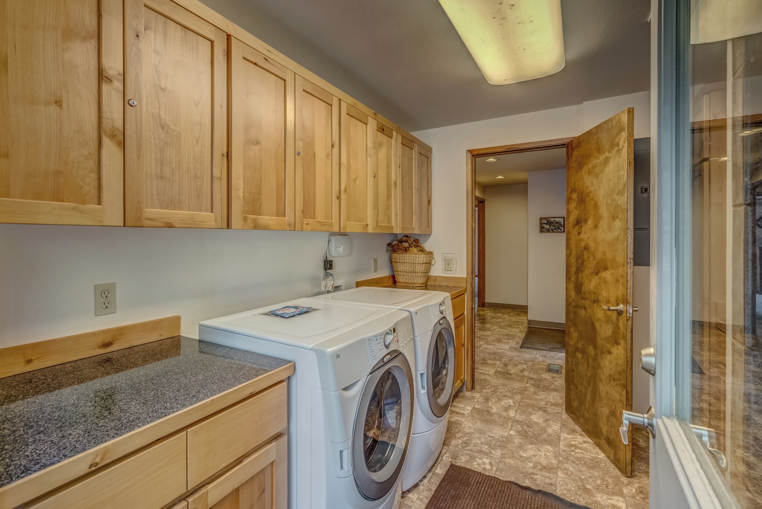 A laundry area with wooden cabinets, a washing machine, and a dryer.