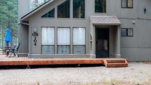 A modern cabin with a deck, large windows, and a door marked "GH 104". - Black Butte Ranch Golf Home 104 (Black Butte Ranch)
