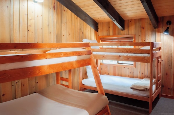 A cabin with wooden walls and floors, featuring bunk beds and a small window. - Black Butte Ranch Golf Home 248 (Black Butte Ranch)