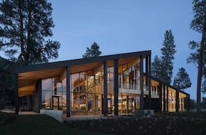 A modern building with large glass windows and a wooden slatted roof.