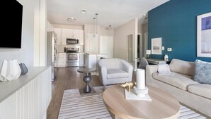 Ein modernes Wohnzimmer mit einer Couch, einem Couchtisch und einer Essecke mit Tisch und Stühlen.