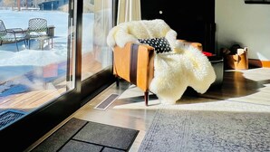En hyggelig stue med stort vindue, pejs og fjernsyn.
