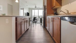 A kitchen with wooden cabinets, a dishwasher, and a ceiling fan.