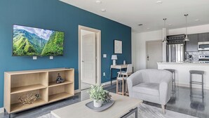 Een moderne woonkamer met een televisie, een bank, een salontafel en een boekenkast.