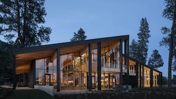A modern building with large windows, a flat roof, and a wooden deck.