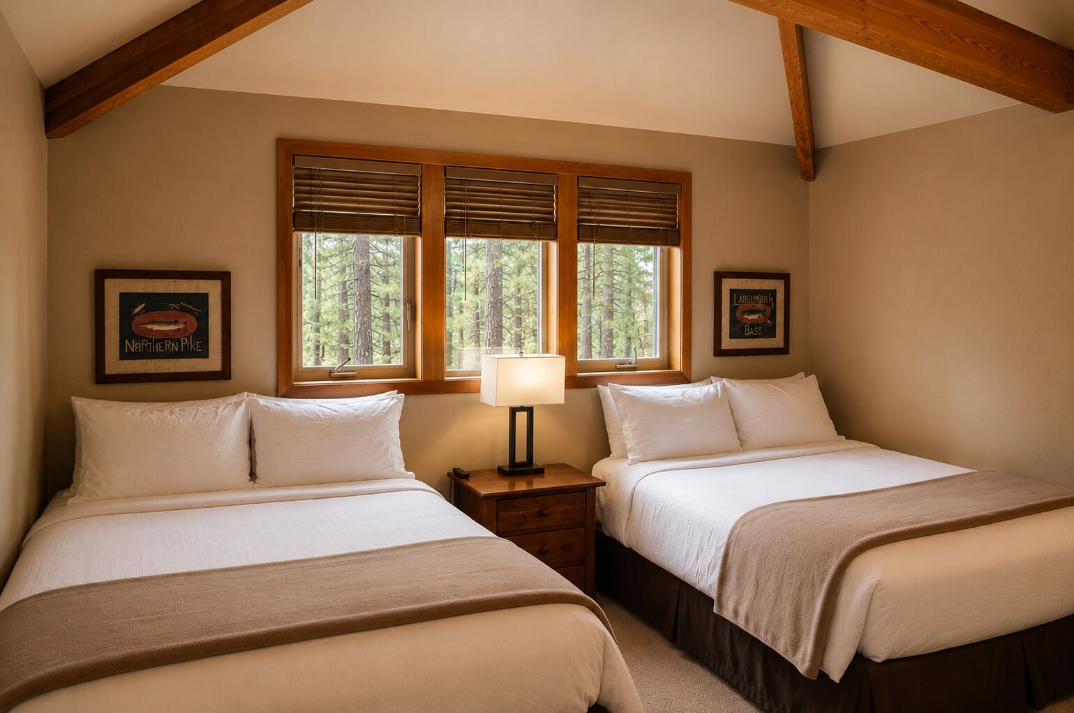 A bedroom with two beds, wooden beams, a window with blinds, and framed artwork.