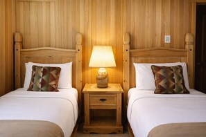 A room with two wooden beds, each with a matching headboard and a decorative pillow. - Black Butte Ranch Spring Home 015 (Black Butte Ranch)
