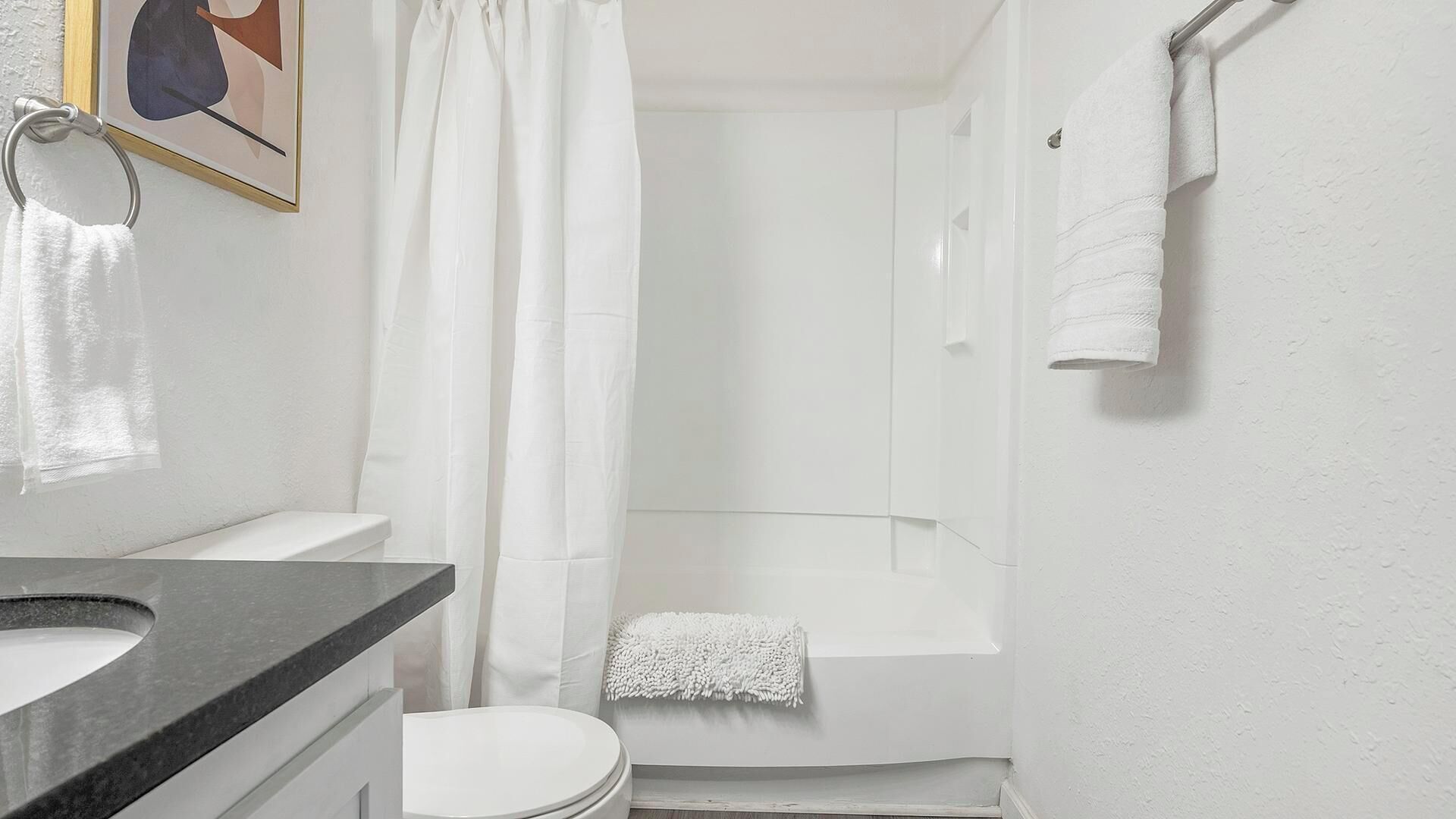 Een badkamer met toilet, wastafel, douche en bad.