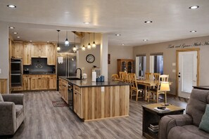 Una cocina moderna con armarios de madera, una isla central e iluminación colgante.