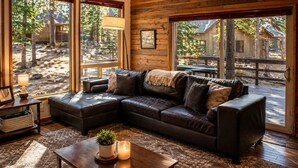 A cozy living room with a sectional sofa, a coffee table with a plant, and large windows offering a view of the outdoors. - Black Butte Ranch South Meadow 139 (Black Butte Ranch)