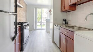 A kitchen with a gas stove, a dishwasher, and wooden cabinets.