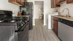 A kitchen with a gas stove, a refrigerator, and a dishwasher. - Landing | Stunning 2BD, Gym, Pool (Greenbelt)