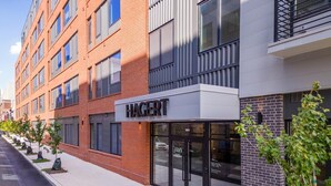 A modern building with a prominent 'HAGERT' sign, featuring a brick facade and large windows. - Landing | Stylish 1BD, Clubhouse, Gym (Philadelphia)