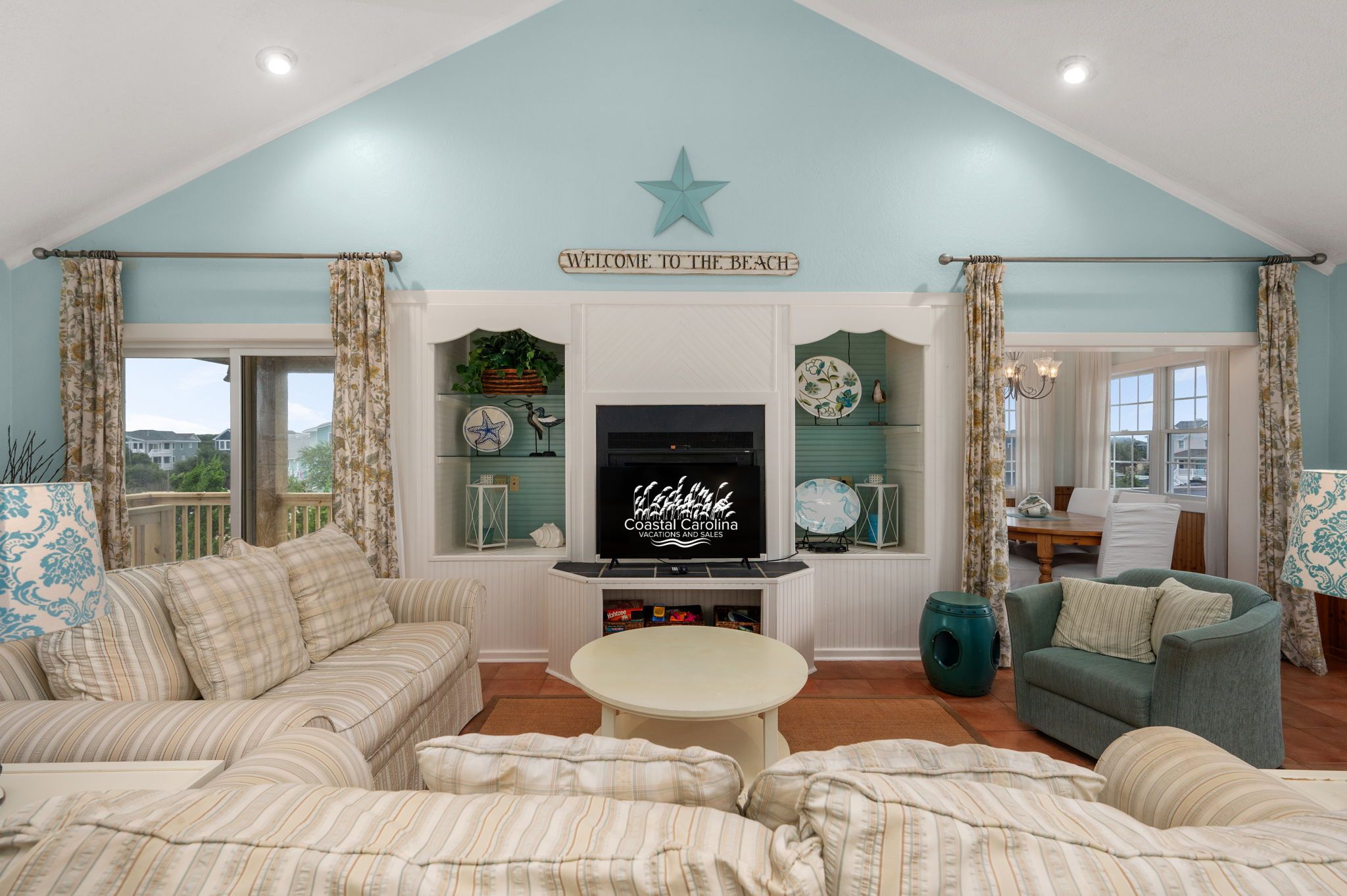 A living room with a television, sofas, a coffee table, and a star decoration on the ceiling.