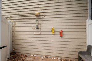 A side view of a house with beige siding, a small outdoor area with a brick pathway, and a wooden bench. - "Ehh, What's up, Duck?": Private Pool, Dog-Friendly, Short Walk to Beach Access (Duck)