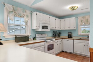 A kitchen with white cabinets, a microwave, a stove, and a dishwasher.
