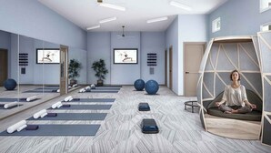 A modern fitness room with yoga mats, exercise balls, and a meditation area.