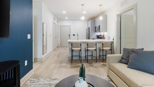 A modern apartment with a kitchen, dining area, and living room.