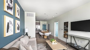 A modern living room with a sofa, coffee table, and artwork on the wall. - Landing | Modern 1BD, Gym, Clubhouse (Leland)