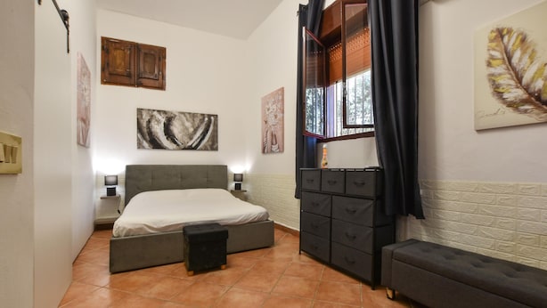 A bedroom with a bed, bedside tables, a dresser, a bench, and artwork on the walls. - 2 bedroom stunning home in Capaci (Capaci)