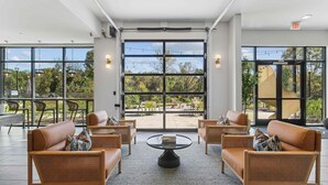 A spacious indoor area with wicker furniture, large windows, and an outdoor view.