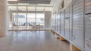 A modern office space with metal filing cabinets, a large window with a view of the street, and three chairs. - Landing | Amazing Studio, Clubhouse, Gym (Denver)