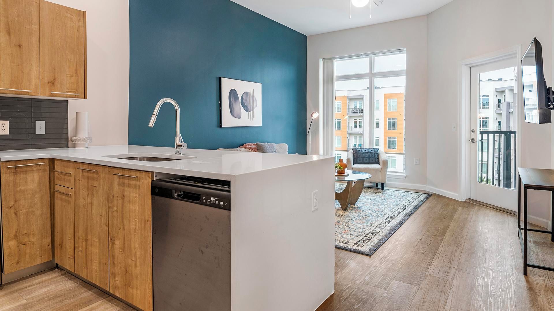 A modern kitchen with wooden cabinets, a dishwasher, and a large island with a sink.