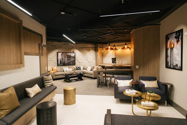 Un salon moderne comprenant un canapé, des fauteuils, une table basse et un coin repas avec des chaises et une table.