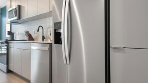 A modern kitchen with stainless steel appliances, a dishwasher, and a microwave.