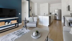 A modern living room with a flat-screen TV, a sofa, and a coffee table. - Landing | Incredible 2BD, Pool (Casas Adobes)