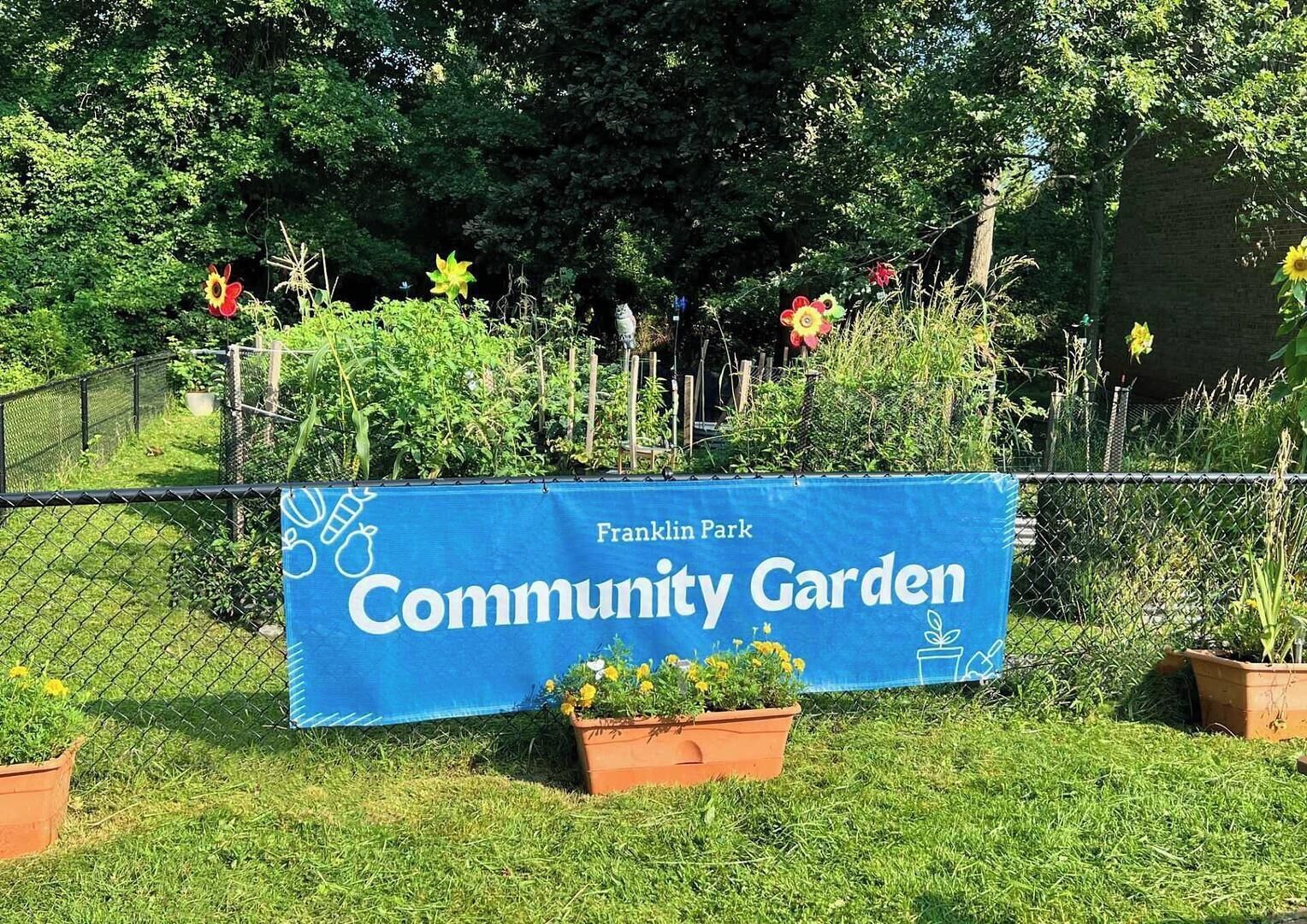 Une banderole bleue sur laquelle on peut lire les mots « Jardin communautaire » et « Parc Franklin », le tout entouré de verdure et de plantes en pot.