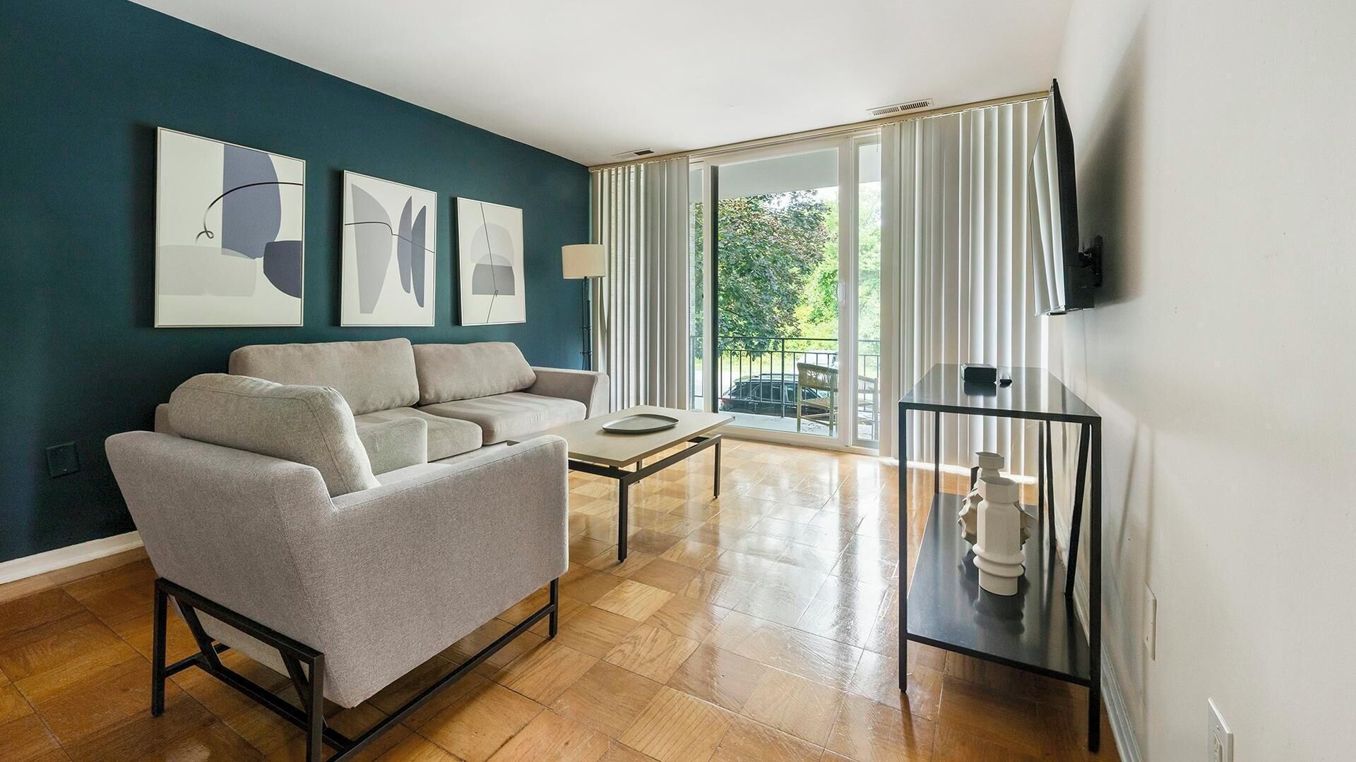Un salon moderne avec un canapé, une table basse et un téléviseur posé sur un meuble.