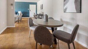 Un espace repas moderne avec une table ronde et quatre chaises grises à revêtement.