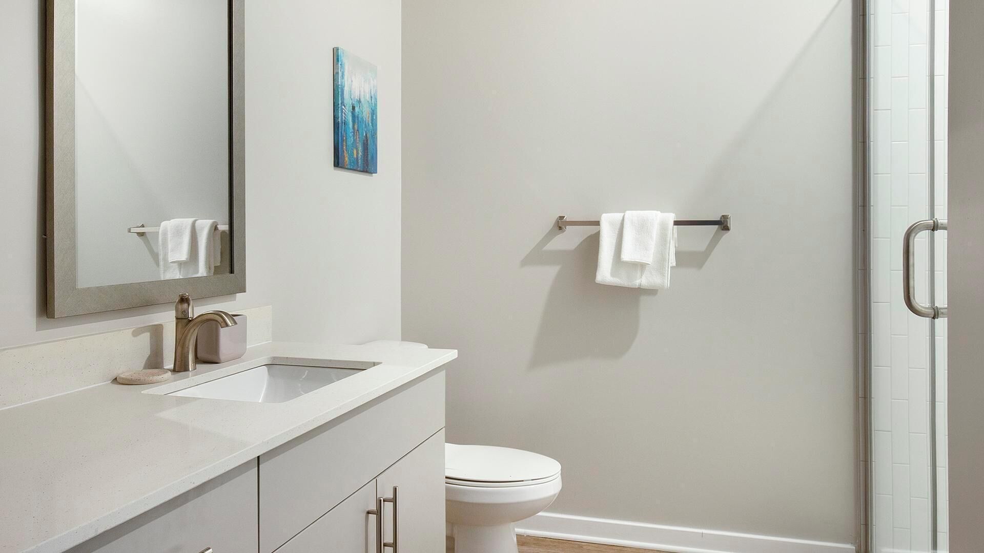 Ein modernes Badezimmer mit Waschbecken, Spiegel und Toilette.