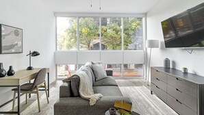 Una sala moderna con un sofá, un televisor y un escritorio.