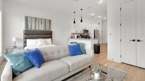 A modern apartment with a living area, a kitchenette, and a bedroom.