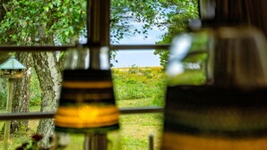 A window view of a grassy field with trees and a bird feeder. - Beautiful home in Tarm with house sea view (Tarm)