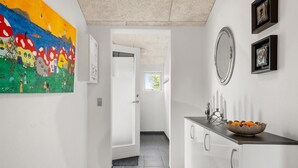 A hallway with a colorful mural, a white door leading to a room, a mirror, and a bowl of fruit on a counter. - Beautiful home in Tarm with WiFi (Tarm)