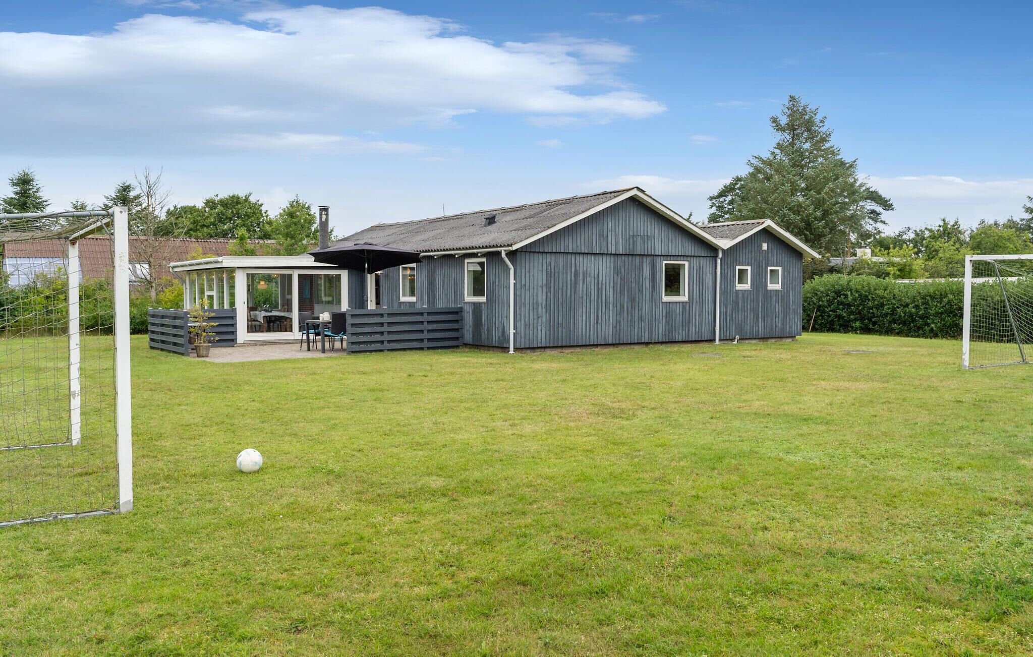 A two-story house with a covered patio and a fenced backyard.