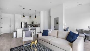 Un appartement moderne comprenant un salon, une cuisine et un coin repas.