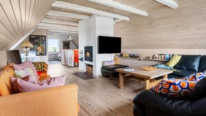 A cozy living room with a wooden ceiling, a fireplace, a television, and a comfortable seating area. - Beautiful home in Hvide Sande with WiFi (Hvide Sande)