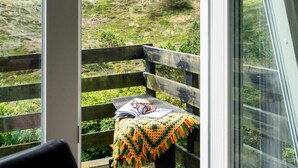 A wooden bench with a crocheted blanket and a book, overlooking a grassy hillside. - Beautiful home in Hvide Sande with WiFi (Hvide Sande)