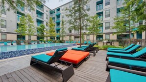 A rooftop pool area with lounge chairs and a pool. - Landing | Chic 1BD, Gym, Rooftop Lounge (San Antonio)